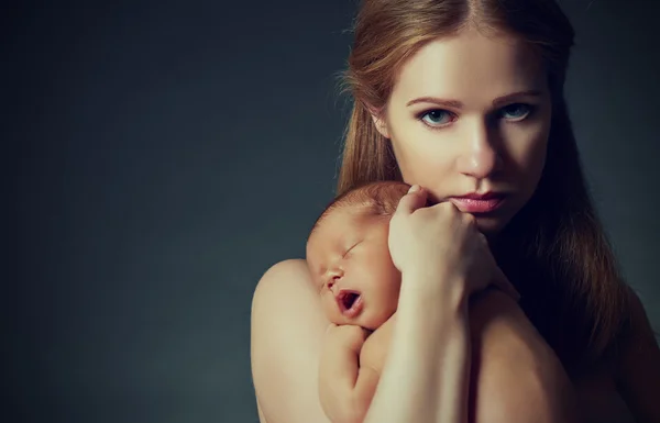 Mãe com um bebê recém-nascido adormecido no escuro — Fotografia de Stock