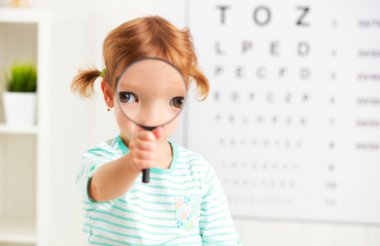 Konsept görme testleri. bir büyüteç ile kız çocuk