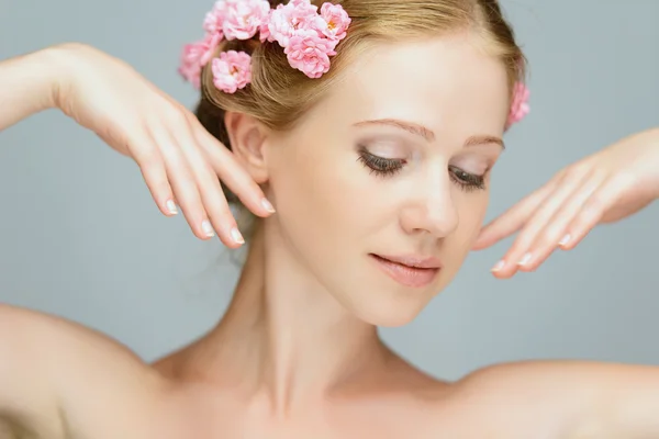 Skönhet ansikte av unga vackra kvinnan med rosa blommor — Stockfoto