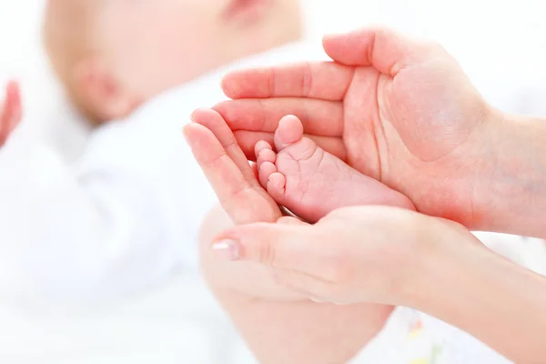 Pés recém-nascido bebê nos braços, mãe — Fotografia de Stock