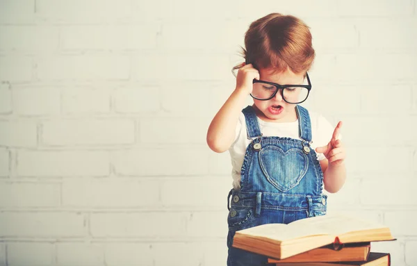 Criança menina com óculos lendo um livros — Fotografia de Stock