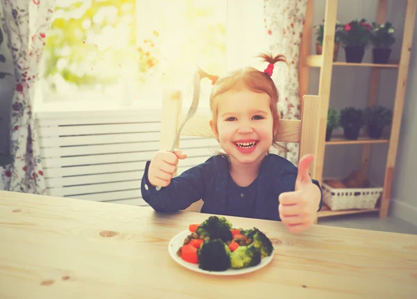Mutlu kız çocuk sebze ve başparmak gösterilmesini yemeyi sever — Stok fotoğraf