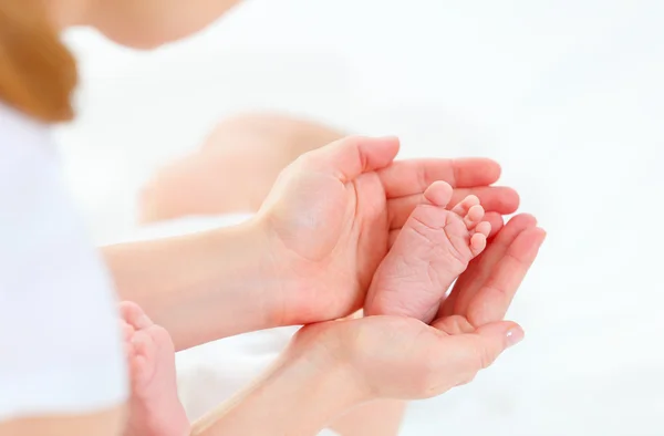 Pies recién nacido bebé en brazos él madre — Foto de Stock