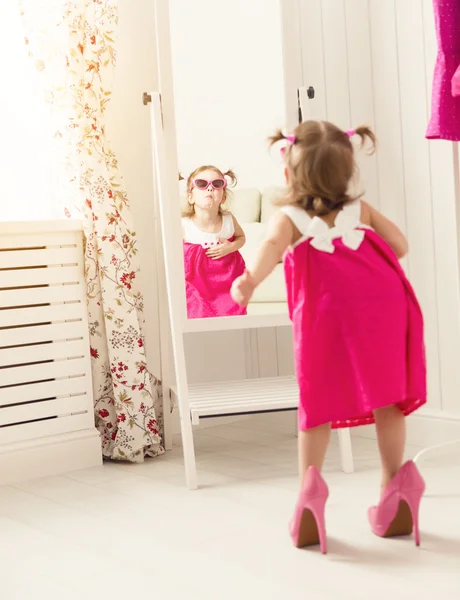 Little girl child fashionista looking in the mirror at home — Stock Photo, Image