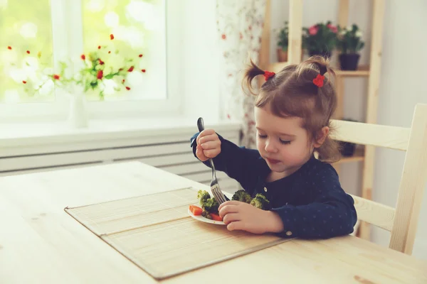 Boldog gyermek lány eszik zöldséget — Stock Fotó