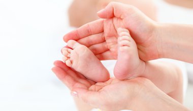 Anne onu kollarında ayak yeni doğan bebek