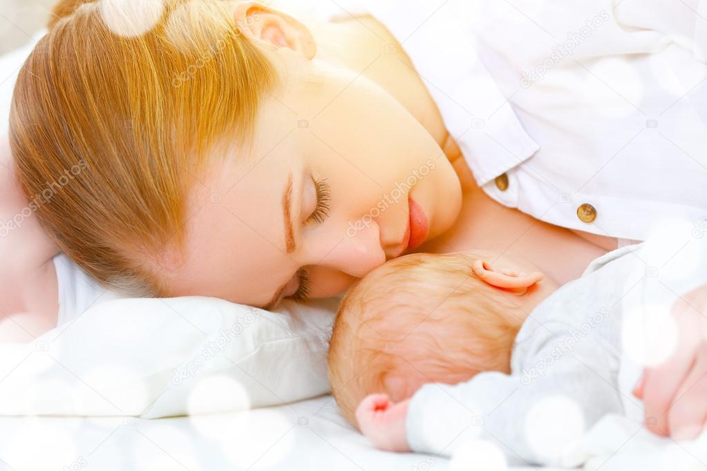 sleeping together and breastfeeding mother and newborn baby in b