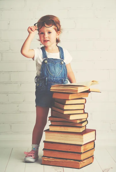 Barn lilla tjej med glasögon läsa en böcker — Stockfoto