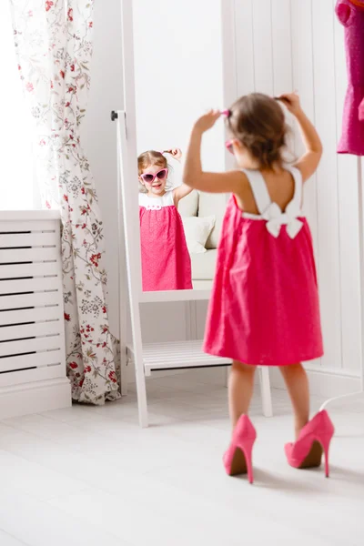 Little girl child fashionista looking in the mirror at home — Stock Photo, Image