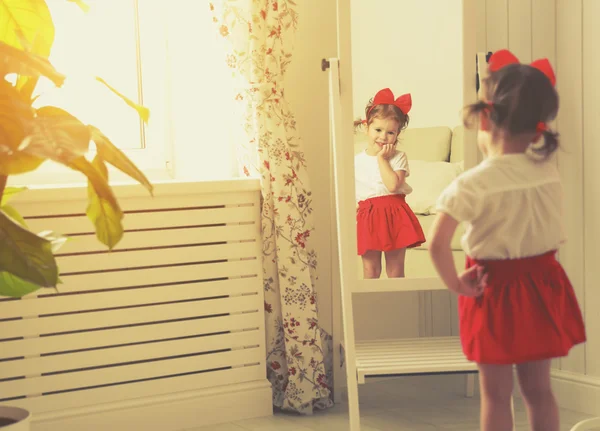 Little girl child fashionista looking in the mirror at home — Stock Photo, Image