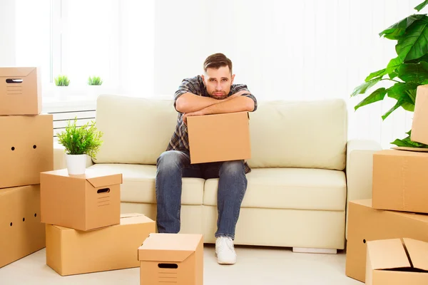 Moving to a new apartment. tired man with cardboard boxes — Stock Photo, Image