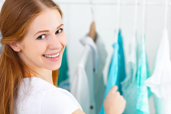 Mulher escolhe roupas em seu guarda-roupa — Fotografia de Stock