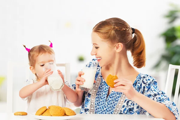 Happy family mother and baby daughter girl at breakfast: biscuit — Stock Photo, Image