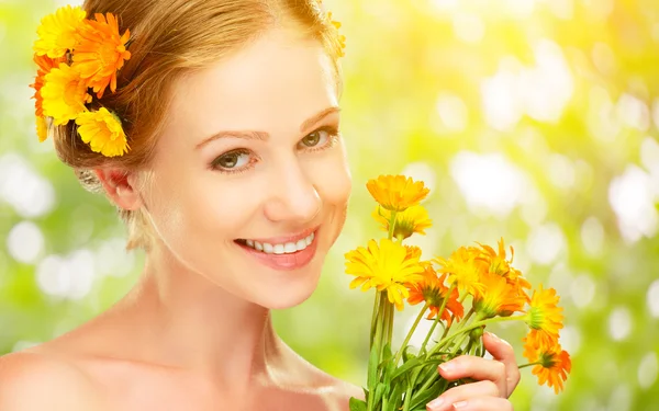 Skönhet ansikte med kvinna med orange gula blommor — Stockfoto