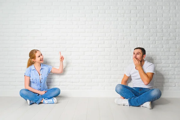 Conceito de problemas de habitação hipotecária. casal na parede em branco — Fotografia de Stock