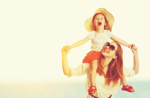 Happy family mother and child daughter on beach at sunset — Stock Photo, Image