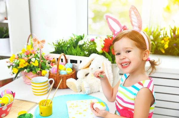 Happy child girl paints eggs for Easter — Stock Photo, Image