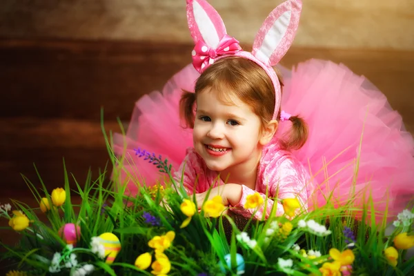 Feliz niña en traje conejo de Pascua conejo en la hierba y fl — Foto de Stock