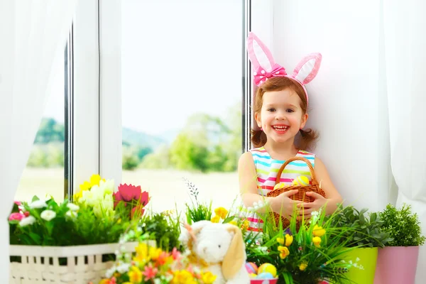 Easter. happy child girl with bunny ears and colorful eggs sitti — Stock Photo, Image