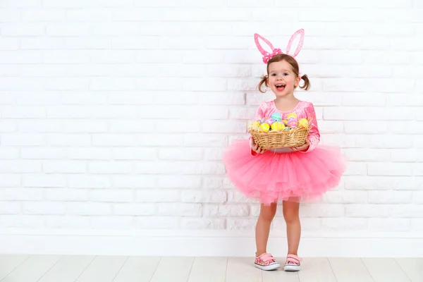 Ragazza felice bambino in un costume coniglio di Pasqua con cesto di — Foto Stock