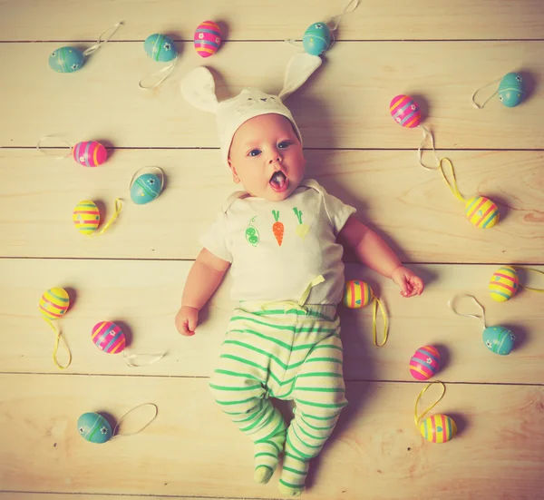 Happy baby kind met Easter bunny oren en eieren — Stockfoto