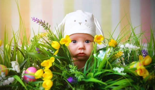 Bebé niño feliz vestido como el conejo de Pascua en la hierba — Foto de Stock