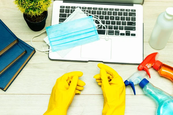 office object : cleaning product on wood table with medical mask and gel and laptop. Professional cleaning products, spring cleaning. Household chemicals