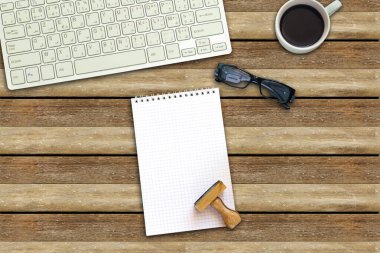 Boş defter, tahta pul ve klavyeli kahve fincanı.