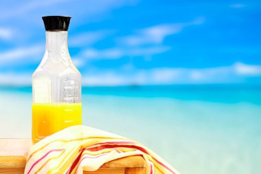 Plajın yanında taze portakal suyu şişesi.