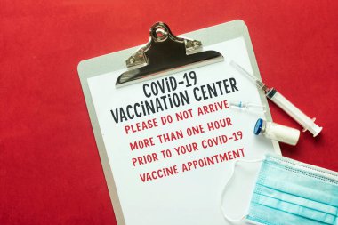 Covid-19 aşı merkezi notu panoda, tıbbi maske enjeksiyon iğnesi