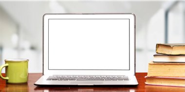 Çalışma alanı dizüstü bilgisayar, kitaplar ve kahve fincanı ile ahşap masanın üzerinde bulanık ofis odası arka planı ile