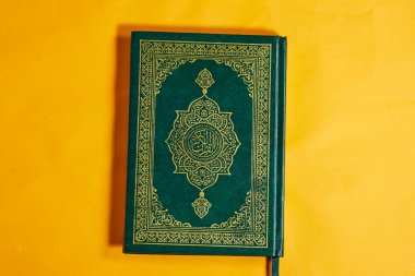 Yeşil kapaklı Arapça kaligrafisi olan Kur 'an' ın kapalı bir kopyası. Arapça 'da, Kuran-ı Kerim, yani Kuran-ı Kerim okunur. Eğitimsel ve kültürel amaçlar için görüntü