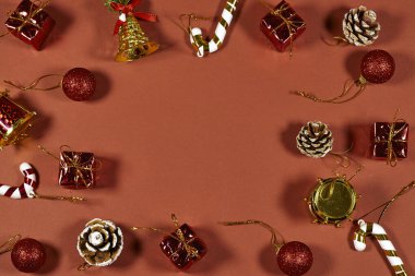 Kırmızı Arkaplanı Hediyeler, Çam kozalakları, Şeker Çubukları ile Çerçeveleyen Şenlikli Noel Süslemeleri