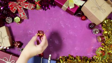 Renkli bayram hediyeleri, kurdeleler ve parıldayan süsler sıcak mor bir zemin oluşturarak Noel kutlamaları için mükemmel neşeli bir festival sahnesi yaratıyor.