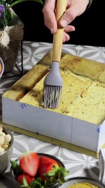 Lezzetli yeşil kremalı çilekli pasta dilimi hazırlayan bir kadın ve şam fıstığı, badem ezmesi. Çilekli Pasta