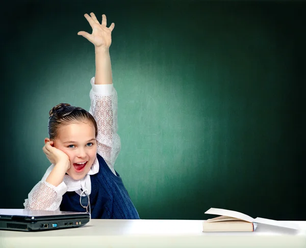 Schoolgirl does lessons sitting behind a desk — Stock Photo, Image