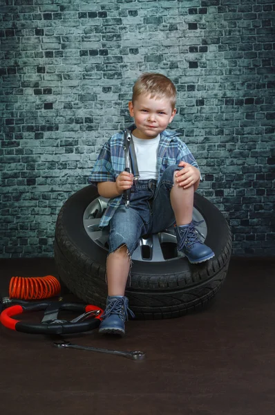 Garçon est engagé dans la réparation de voitures à roues — Photo