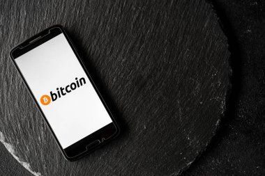 Bir akıllı telefonun ekranında Bitcoin dijital kripto para logosu.
