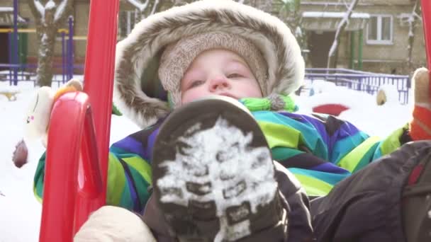 Niño en columpio en invierno — Vídeos de Stock