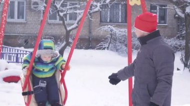 Çocuk kışın salıncak üzerinde