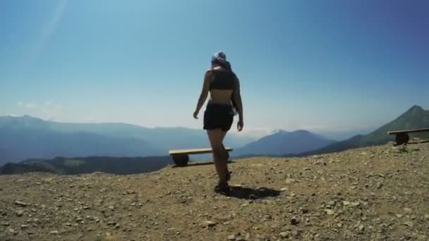 Девушка на скамейке в горах — стоковое видео