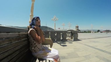 Kız bankta oturur ve dua ediyor