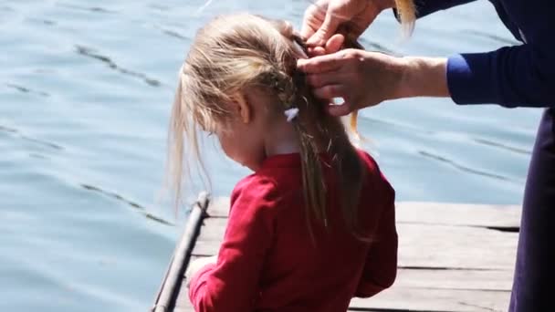 Madre niña trenzas cabello en la naturaleza — Vídeos de Stock