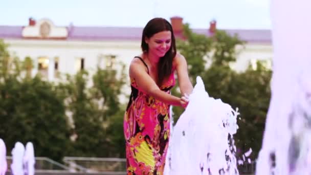 Девушка играет с фонтаном — стоковое видео