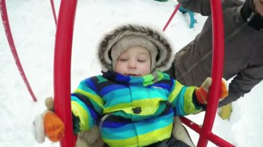 Çocuk kışın salıncak üzerinde
