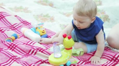 Doğada oyuncakla oynayan erkek bebek