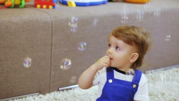 Niño en la habitación disfruta de burbujas de jabón mamá — Vídeo de stock