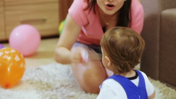 Kind im Zimmer genießt Seifenblasen Mama — Stockvideo