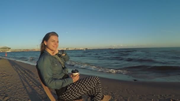 Chica en la playa con café — Vídeo de stock