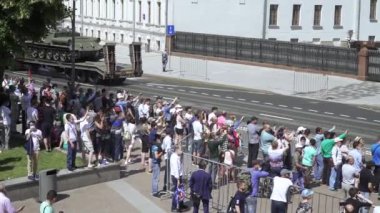 İzleyiciler ve askeri teçhizat geçit töreninden geliyor.